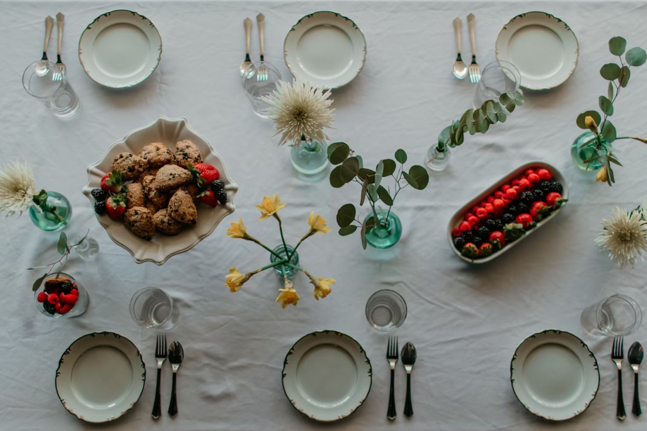 a party table laid including small plates and flowers