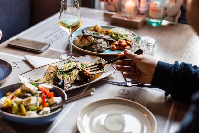 person picking up food with fork from plate