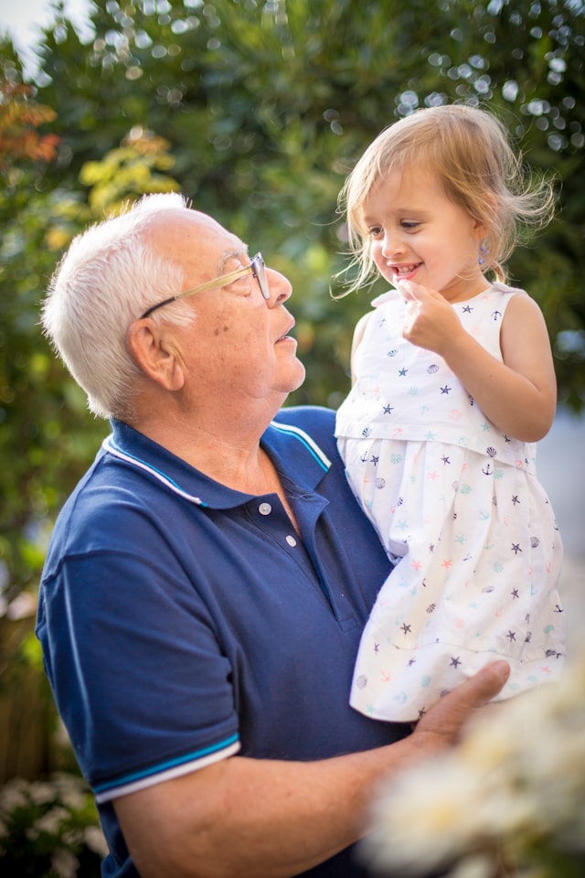 grandad holding granddaughter and smiling