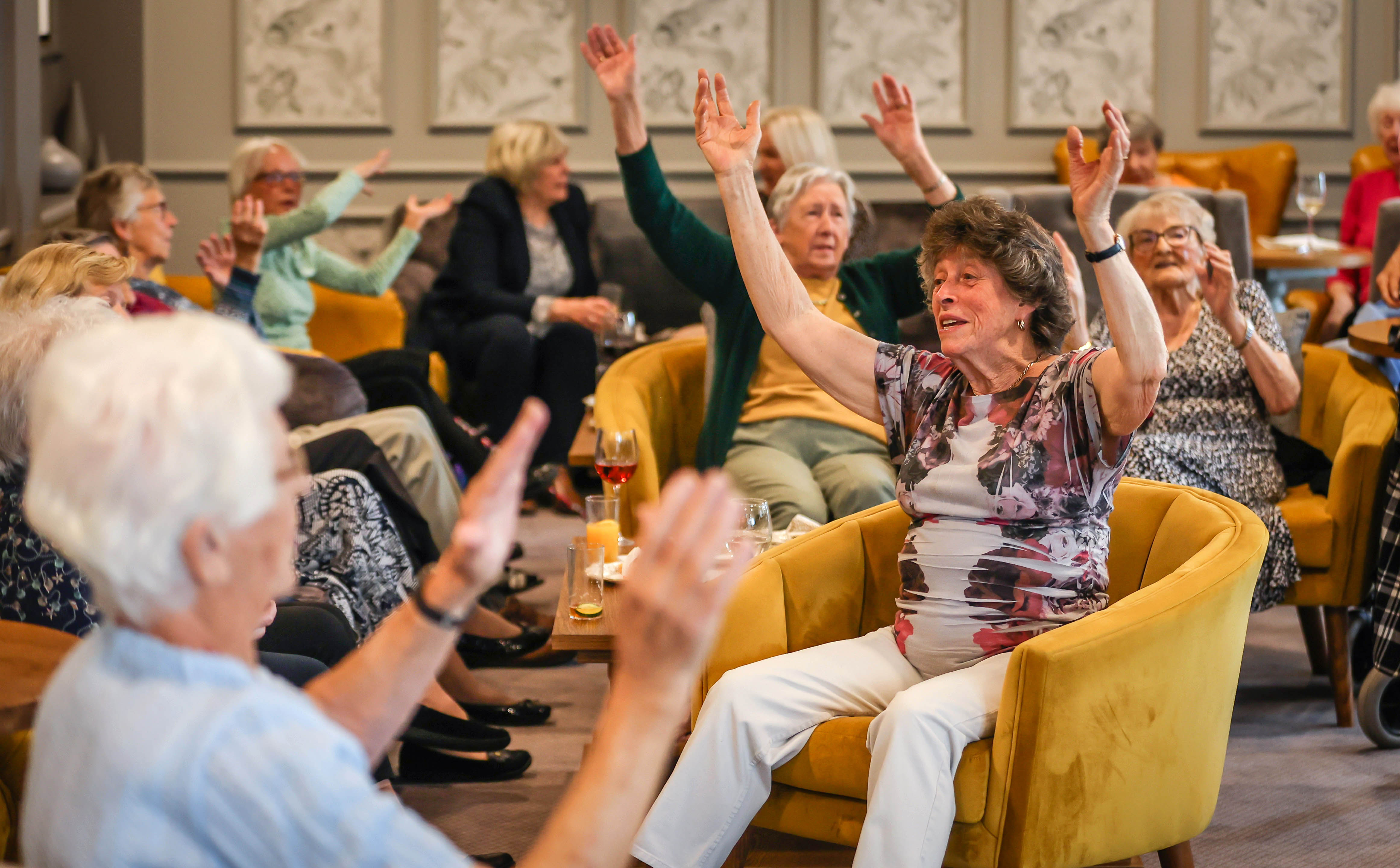 Group of seniors dancing while sitting