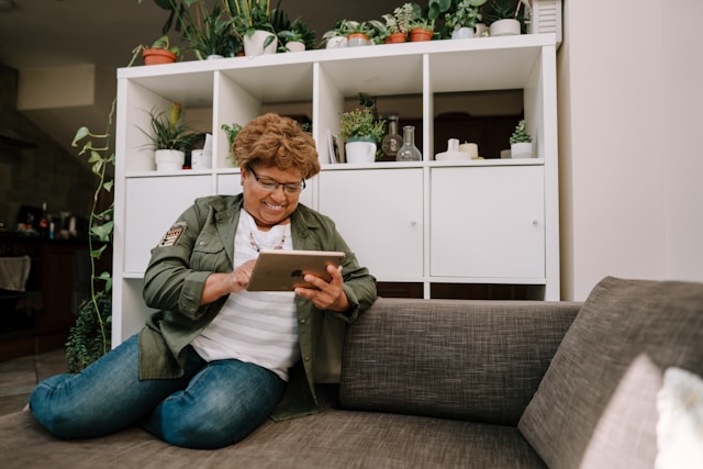 women sitting on sofa smiling at tablet