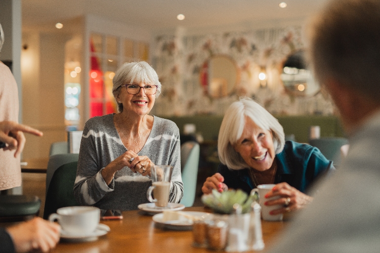 Group of seniors smiling drinking tea