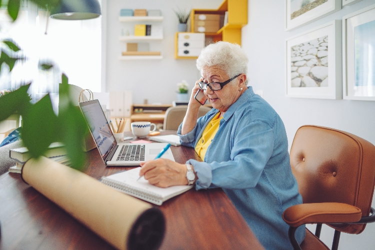 Senior woman working at a desk on the phone